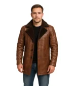 A men’s mid-length coat in distressed cinnamon brown leather, featuring a plush faux-fur collar and a rugged, vintage-inspired finish.