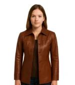 A women’s long leather coat in a rich cognac brown shade, featuring a belted waist, wide lapels, and a smooth polished finish.