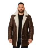 A men’s brown Bane-inspired leather coat featuring a distressed finish, a thick cream-colored shearling collar, and a rugged, long-length design.