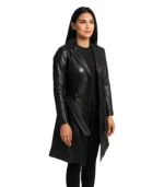 A long-length women’s black leather trench coat featuring a double-breasted front, waist-cinching belt, and elegant wide lapels.