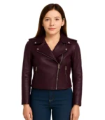 A young woman wearing a sleek asymmetrical lambskin leather jacket with a professional lapel collar and silver-toned hardware.
