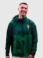 Close-up view of green hooded qualifier jacket showing zipper detail, stitching, and crest-style chest finish for a neat look.