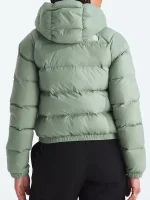 Back view of women’s olive green puffer jacket showing full coverage, hood, and clean winter silhouette.
