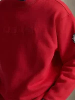 This view helps buyers see how the sweatshirt sits on the body and how the mockneck collar frames the neck area. It’s easy to layer under a puffer or coat, and it also looks great worn on its own. Keep the rest of your outfit simple—black, grey, navy, or denim works best—so the red shade stays the highlight.